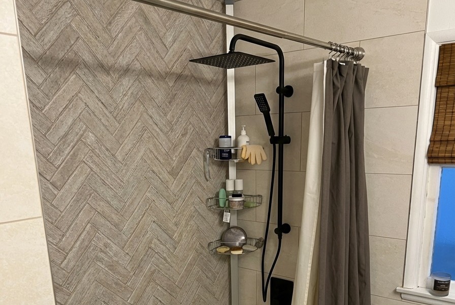 Bathroom renovation with herringbone accent tile and matte black rain shower fixtures